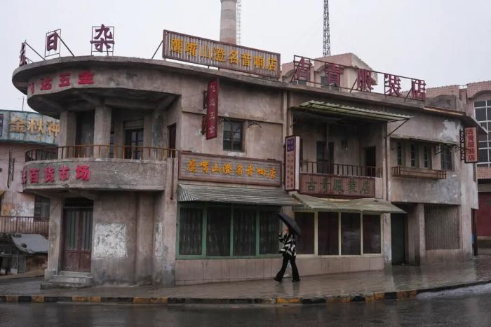 游客对照电影截图寻“同款” 《欢迎来龙餐馆》石头门楼成打卡